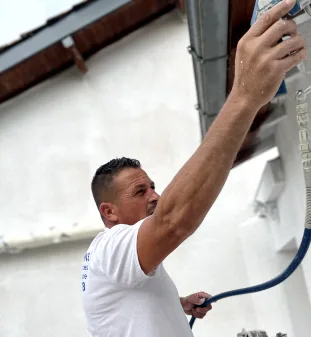 Artisan entrain de peindre une façade à Montauban